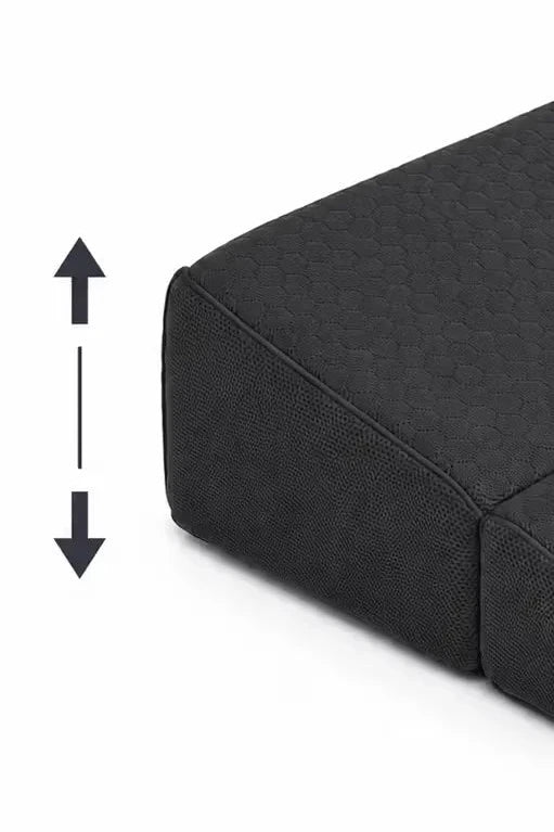 Close-up of a charcoal icare Supporta Bed Wedge corner with a vertical double-arrow graphic indicating height or depth on a white background.