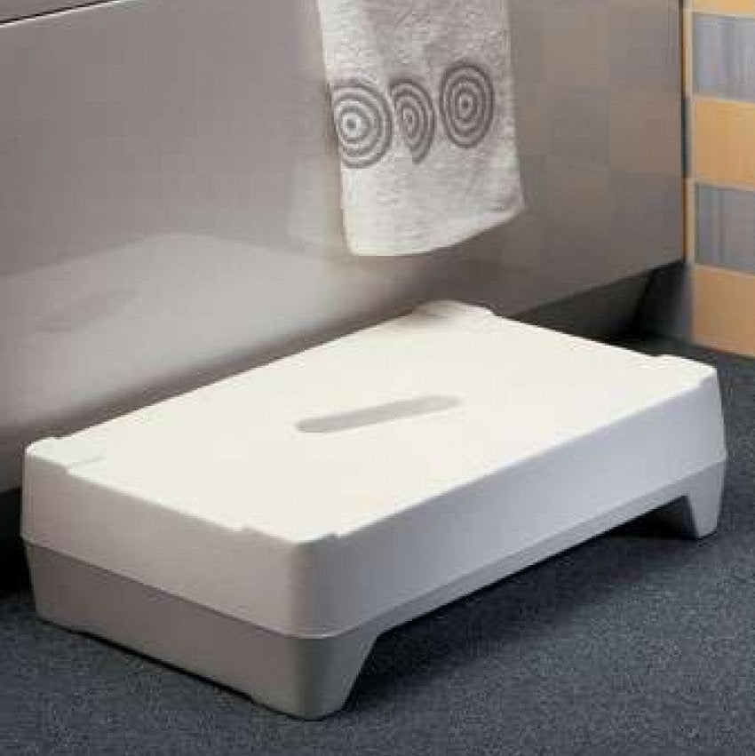 A white Ashby Bathroom Two Step, positioned in front of a bathtub in a bathroom setting.
