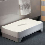 A white Ashby Bathroom Two Step, positioned in front of a bathtub in a bathroom setting.