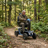 Man using a Pride Mobility Outback Mobility Scooter in a forest setting