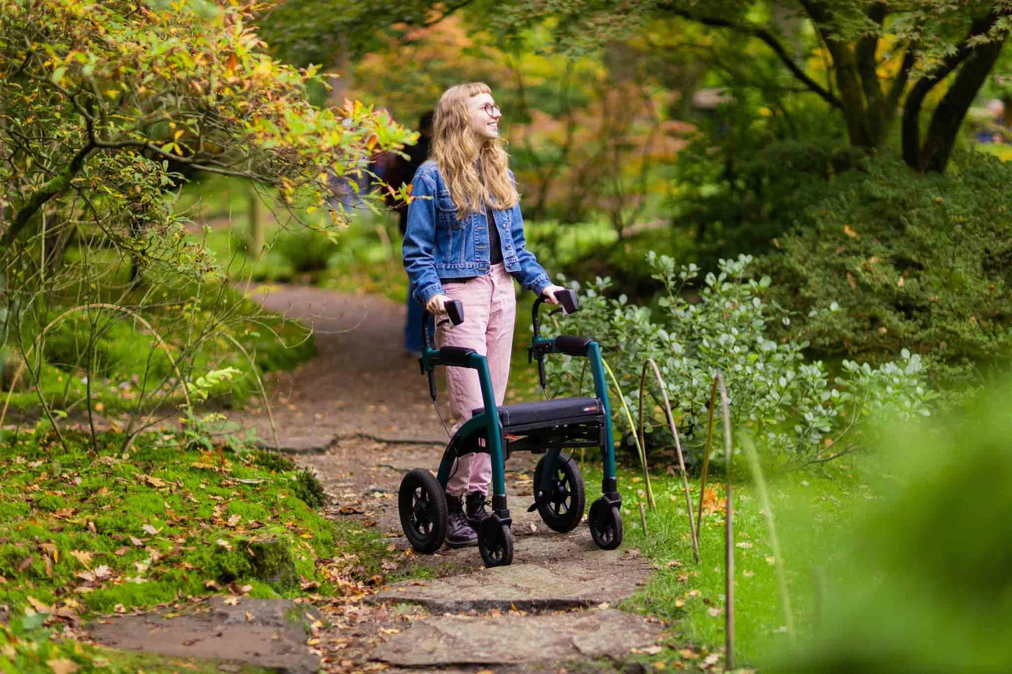 Woman using a Rollz Motion Performance 2-in-1 Walker Wheelchair in a park setting
