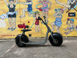 Kaaspeed K1S Fat Tyre Self Balancing E Scooter in front of a colorful mural on a wall.