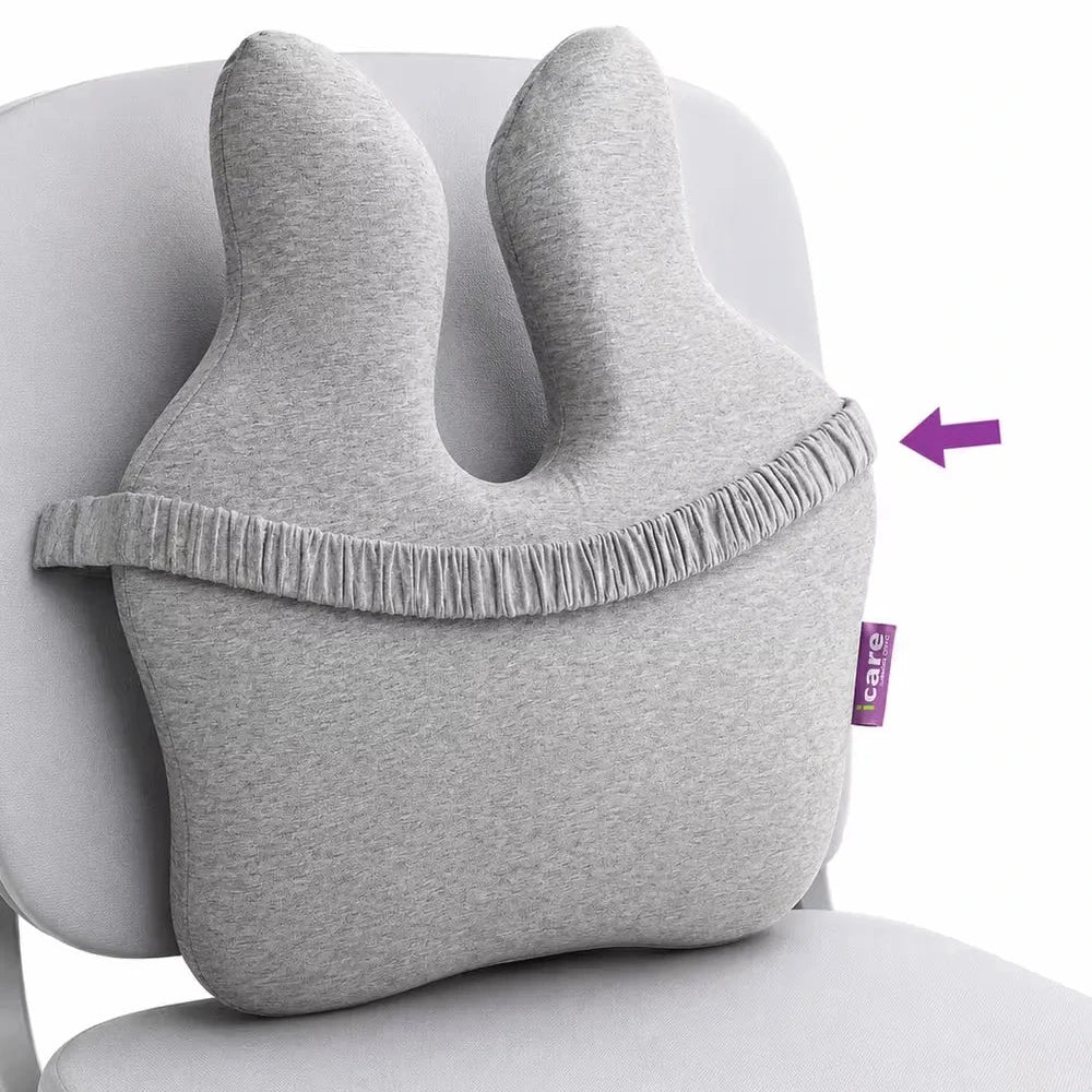 A icare Reform Full Back Support cushion with back elastic strap, shown resting on a white chair. A purple arrow points to the side of the pillow where a small purple 'care' brand tag is attached.