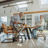 Two people using Saljol Indoor Walker at a dining table in a modern home setting.
