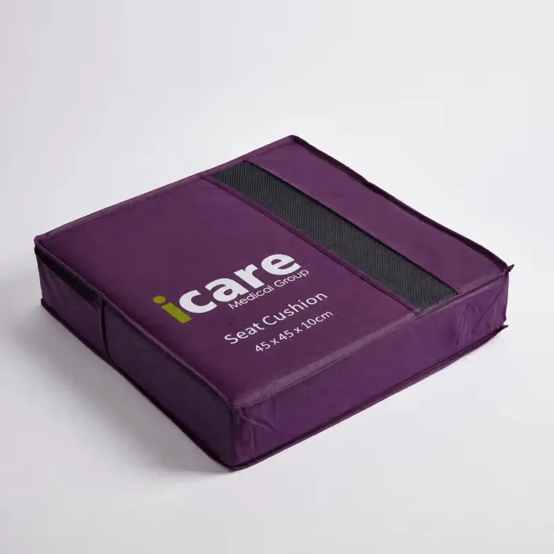 A purple fabric icare Supporta Seat Cushion with a black strap and white printed branding, photographed on a clean light gray studio background.