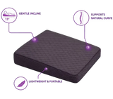 A charcoal icare Posture Wedge shown on a white background with three purple callout graphics and text highlighting its features: gentle 15-degree incline, support for natural curve, and lightweight portability.