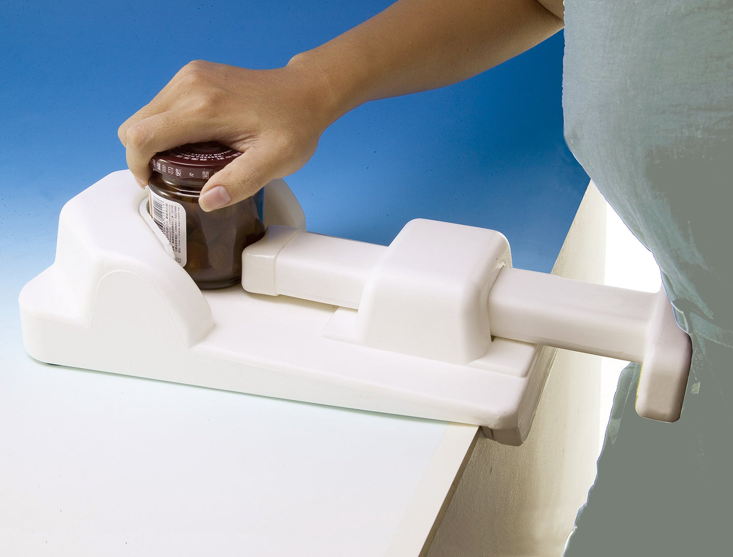 Hand using a jar opener on a blue background