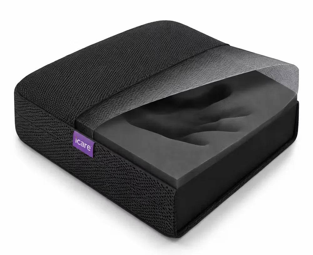 A charcoal icare Supporta Seat Cushion with a textured fabric cover, shown with its transparent protective plastic lid partially peeled back to reveal the contoured foam insert.