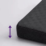 Close-up of the corner of a dark charcoal icare Posture Wedge with a subtle geometric pattern on the top surface and a textured side edge, shown on a light gray background with a purple double-arrow graphic indicating height.