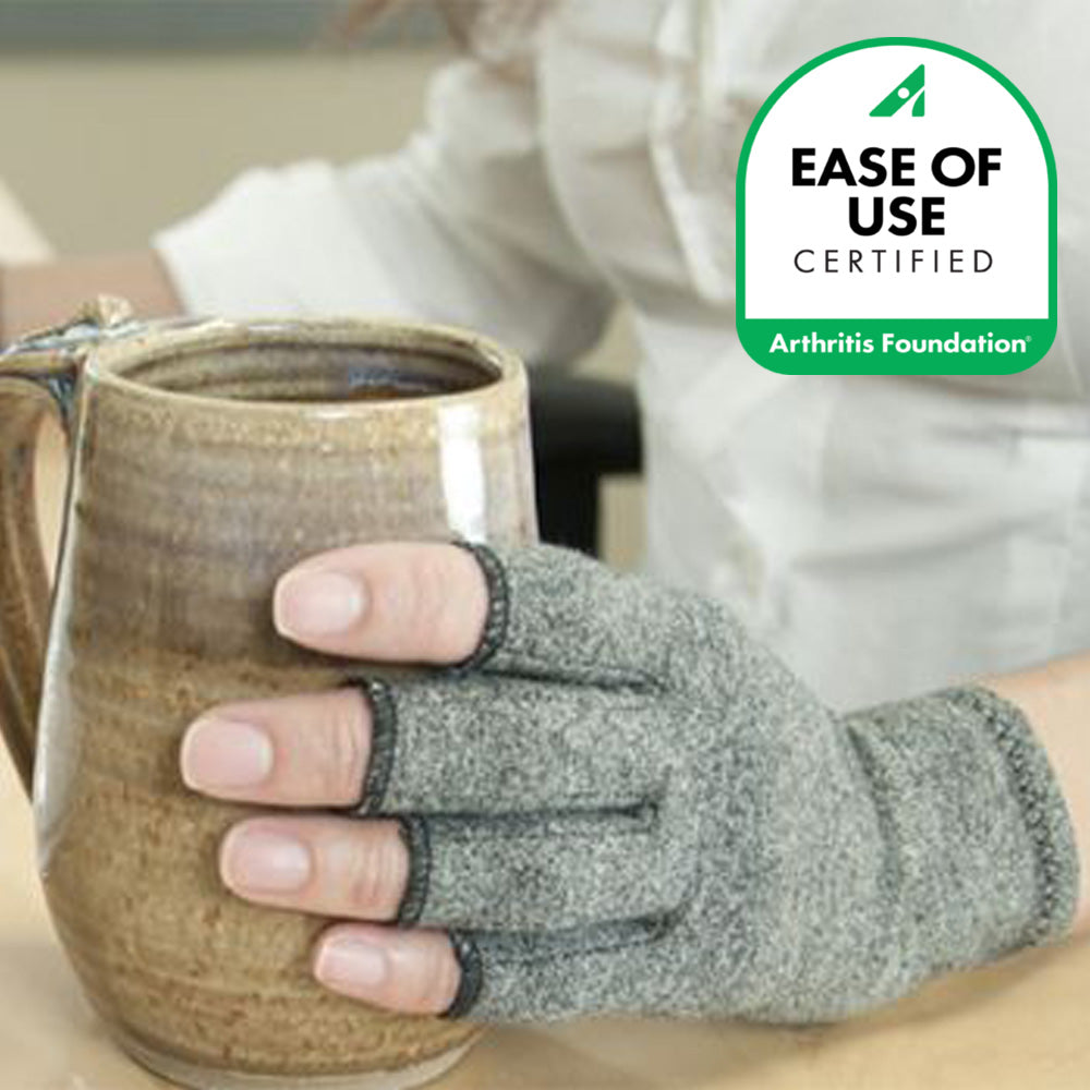 Hand wearing a I‑MAK Compression Arthritis Gloves holding a ceramic mug, with 'Ease of Use Certified' Arthritis Foundation logo.
