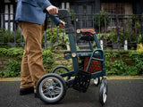 Person pushing a greenUplivin Gavo 2-in-1 Walker Wheelchair with a brown seat in an outdoor setting.