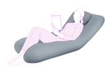 Illustration of a person lying on a gray icare Supporta Body Pillow reading a book.