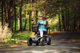 Person using a Pride Mobility Pathrider Endurance Mobility Scooter Black on a path in a forest