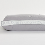 Gray icare Conform Pillow with white trim on a light gray background