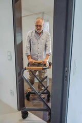 Man standing in front of a mirror with a Saljol Indoor Walker , wearing glasses and a light-colored shirt.