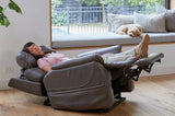 Person relaxing in a Smoke Theorem Winslow Power Lift Recliner Chair in a home setting with a dog on a windowsill.