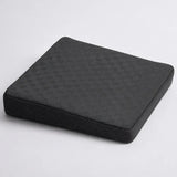 A charcoal icare Posture Wedge cushion with a textured honeycomb pattern on the top surface and a mesh-like side panel, shown on a light gray background.