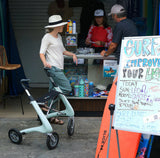 Person using a byACRE Nordic Pioneer in front of a store with a sign about surfing and improving life.