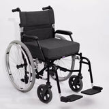 A manual wheelchair with a charcoal icare Supporta Seat Cushion, black armrests, and a black metal frame with silver-spoked rear wheels and black front casters, photographed on a light gray studio background.
