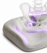 A close-up of a icare Reform Seat Support pillow in light gray fabric, with a translucent anatomical hip and lower back model overlaid to illustrate support placement, on a white background.