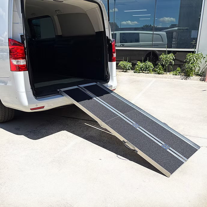 Van with an extended TriFold ramp in a parking lot
