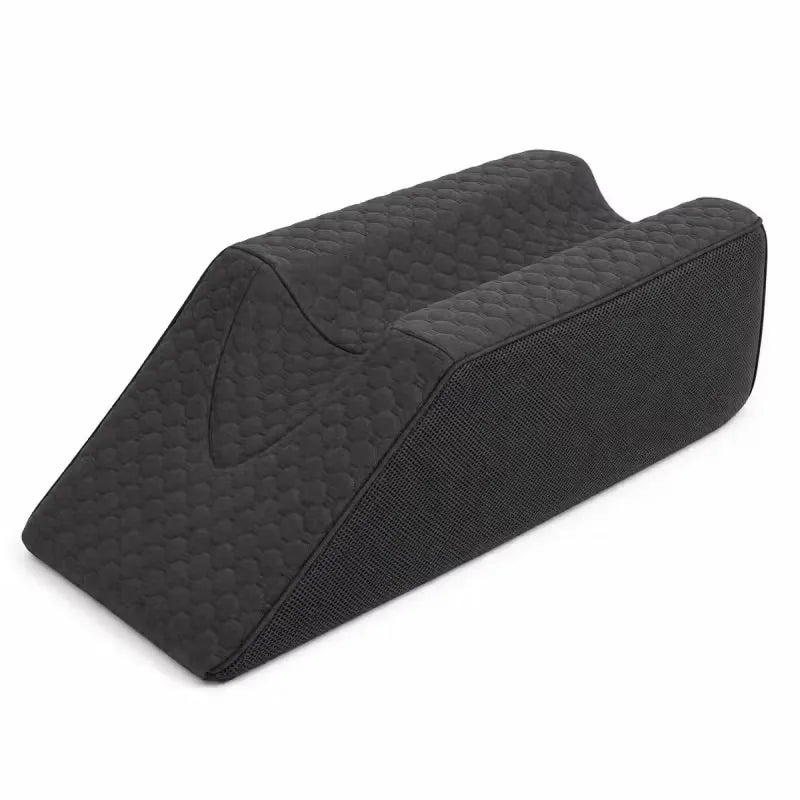 A charcoal icare Leg Raiser pillow with a quilted diamond pattern on the top surface and a textured fabric side, shown on a plain white background.