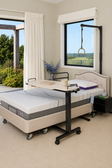 iCare Standard Over Bed Table in White Ash positioned over an adjustable bed
