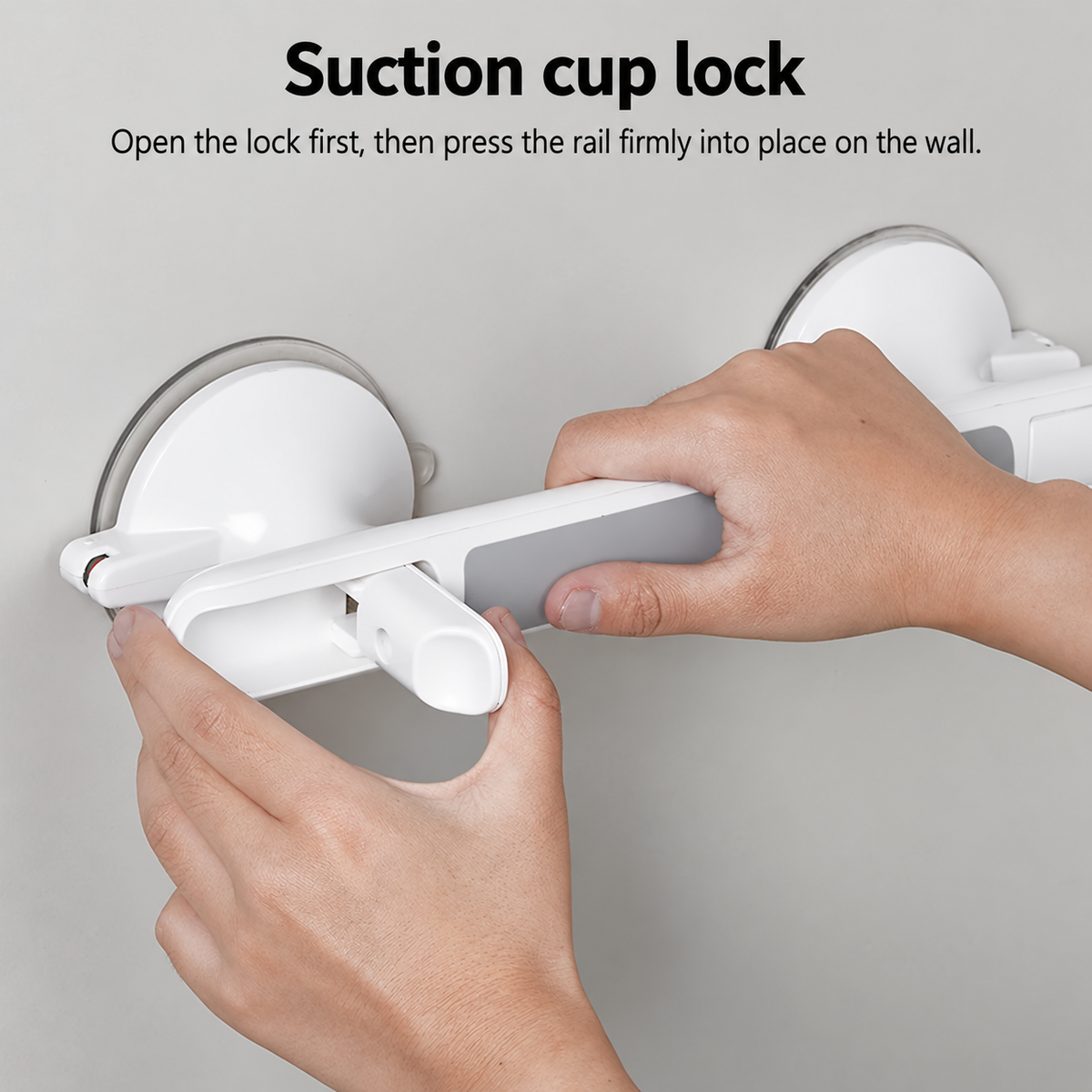 A close-up of a person's hands installing a white suction cup lock rail onto a gray wall, with black instructional text at the top reading 'Suction cup lock' and a subtitle explaining how to open the lock and press the rail into place.